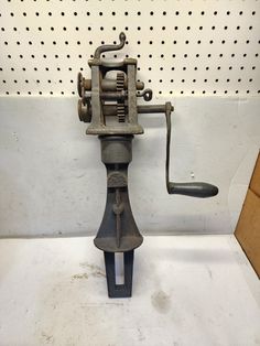 an old fashioned fishing reel on display in a room with perforated metal pegs