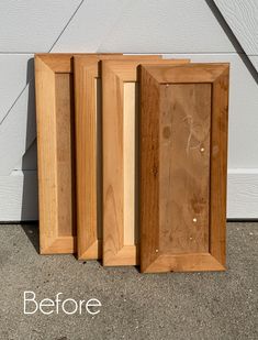 three wooden frames sitting next to each other on the ground in front of a wall