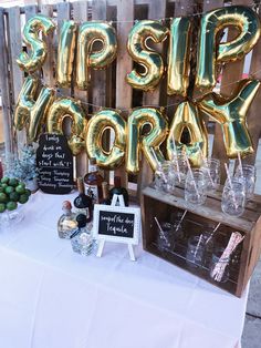 a table topped with lots of balloons and wine glasses next to a sign that says sippy party