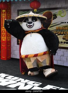 a giant panda mascot dressed as a mexican wrestler in front of a movie theater entrance