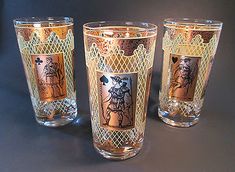 three old fashioned glasses sitting next to each other on a black tableclothed surface