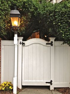 a white gate with a light on it