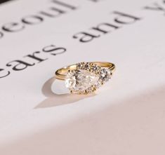 a close up of a diamond ring on top of a piece of paper with words