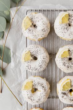 lemon donuts with white frosting and sprinkles on a cooling rack