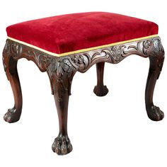 an ornately decorated bench with red velvet upholstered on the bottom and gold trimmings