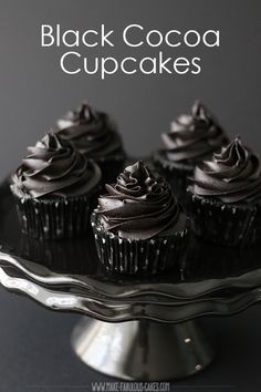 chocolate cupcakes on a cake plate with the words black cocoa cupcakes