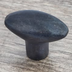 a close up of a black knob on a wooden surface