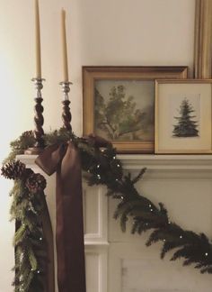 a mantel decorated for christmas with candles and garland