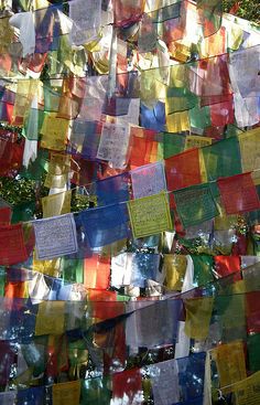 many colorful flags hanging from the side of a building