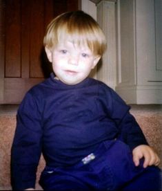 a young boy is sitting on the floor