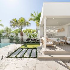 a house with a swimming pool surrounded by palm trees