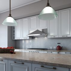 two lights hanging over a kitchen island with marble counter tops and white cabinets in the background