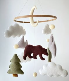 a mobile made to look like a bear in the sky with clouds and trees hanging from it