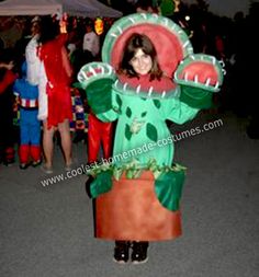 a woman in a costume standing next to other people at an outdoor event with lights and decorations