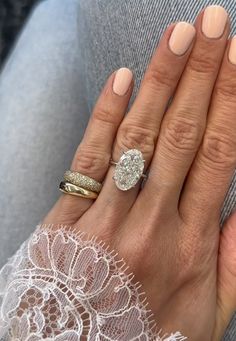 a woman's hand with two wedding rings on her left and an engagement ring on her right