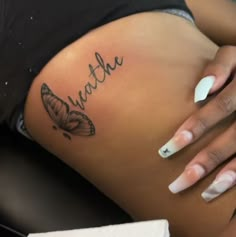 a close up of a woman's stomach with a butterfly tattoo on her belly