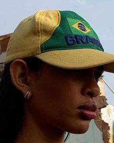 a woman wearing a green and yellow hat with the word brazil on it's side