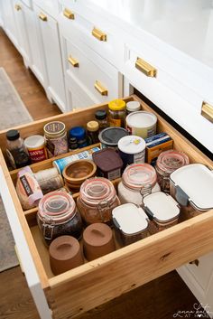 an open drawer in a kitchen filled with spices