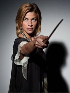 a woman holding a wand in her right hand