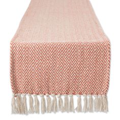 an orange and white herringy table runner with fringes on the end, in front of