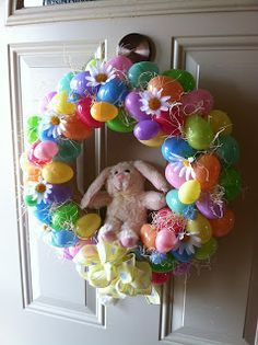 a colorful wreath with an easter bunny on the front door and balloons in the shape of flowers