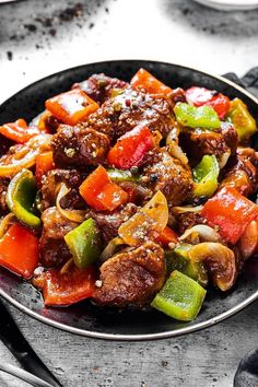 a bowl filled with meat and vegetables on top of a table