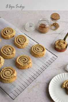 some cookies are on a cooling rack next to a cup of coffee