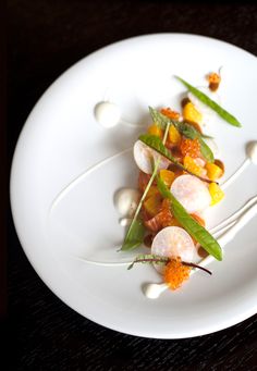 a white plate topped with lots of veggies on top of a wooden table