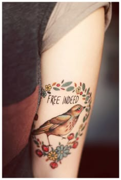 a woman's arm with a bird on it and the words free inked