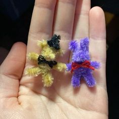 two small teddy bears are sitting on someone's hand