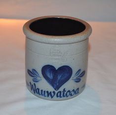 a ceramic jar with a blue heart on it