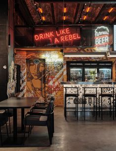 the inside of a restaurant with neon signs and tables, chairs, and bar stools