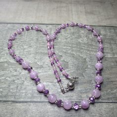 A subtle and sparkly purple necklace that is approx59cm (22in) long. At each end of the necklace five 4mm purple Angelite beads alternate with six 4x2mm unusual purple clear/opaque Czech Crystal rondelle beads. Then nine more of the Crystals alternate with nine 6mm Angelite beads, while in the middle of the necklace are eleven 6x4 Crystals alternating with ten 8mm Angelite beads. All these are separated by silver lined clear Glass seed beads. All the metal work is Stainless Steel including the magnetic clasp and the earwires on the free matching earrings. Necklace and earring come enclosed within a pink velvet bag. Angelite was first discovered in Peru in 1987. It is a peaceful stone infusing you with serenity and positivity. It supposedly enhances ones connections with Angels. This is a c Purple Beaded Necklaces With Faceted Beads As Gift, Purple Faceted Beads Necklace As Gift, Purple Faceted Beads Necklace For Gift, Elegant Lavender Crystal Necklace With Round Beads, Purple Adjustable Crystal Necklaces With Faceted Beads, Purple Amethyst Faceted Bead Crystal Necklaces, Lavender Faceted Beads Crystal Necklace Gift, Lavender Single Strand Round Bead Jewelry, Purple Amethyst Round Bead Necklaces