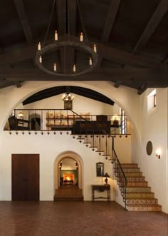 the inside of a house with stairs and a fire place