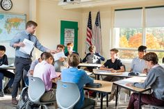 a man standing in front of a classroom full of kids sitting at their desks