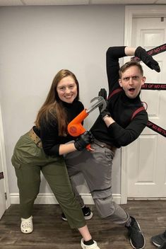 two people are posing in front of a door with chains attached to their arms and hands