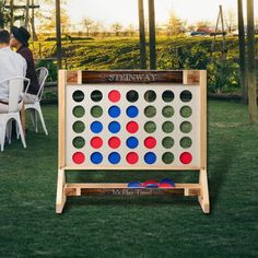 a giant game set up in the middle of a lawn with people sitting around it