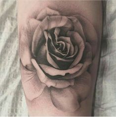 a black and white rose tattoo on the arm