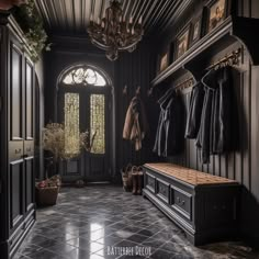 the entryway is decorated in black and features an ornate bench, coat rack, and chandelier