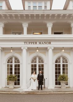 a bride and groom standing in front of the tupper manor