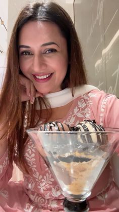 a woman sitting in front of a glass bowl