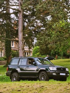 a black suv parked in front of a tree