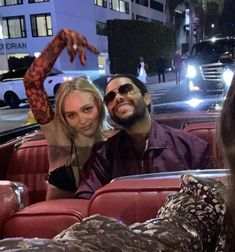 a man and woman sitting in the back of a car