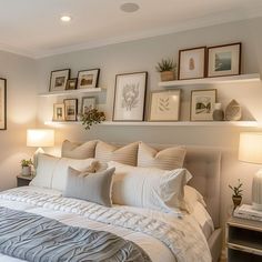 a large bed sitting in a bedroom next to two lamps and pictures on the wall