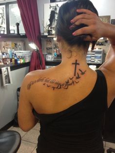 a woman with a cross tattoo on her back