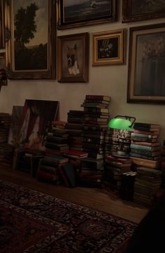 a room filled with lots of books and pictures on the wall next to a lamp