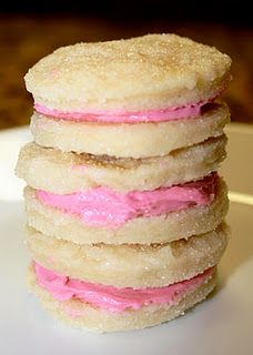 a stack of cookies with pink frosting on top