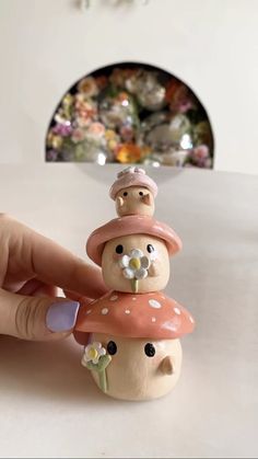 a hand is holding a small toy with mushrooms on it