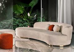 a couch and ottoman in a room with plants