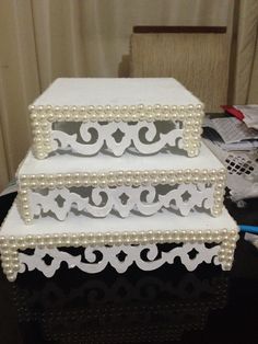 three tiered wedding cake with pearls on top